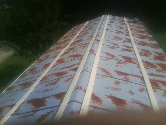 Rusted metal roof panels with new wood purlins before replacement — Storm Damage Roof Repair in Russell by Roofing Brothers